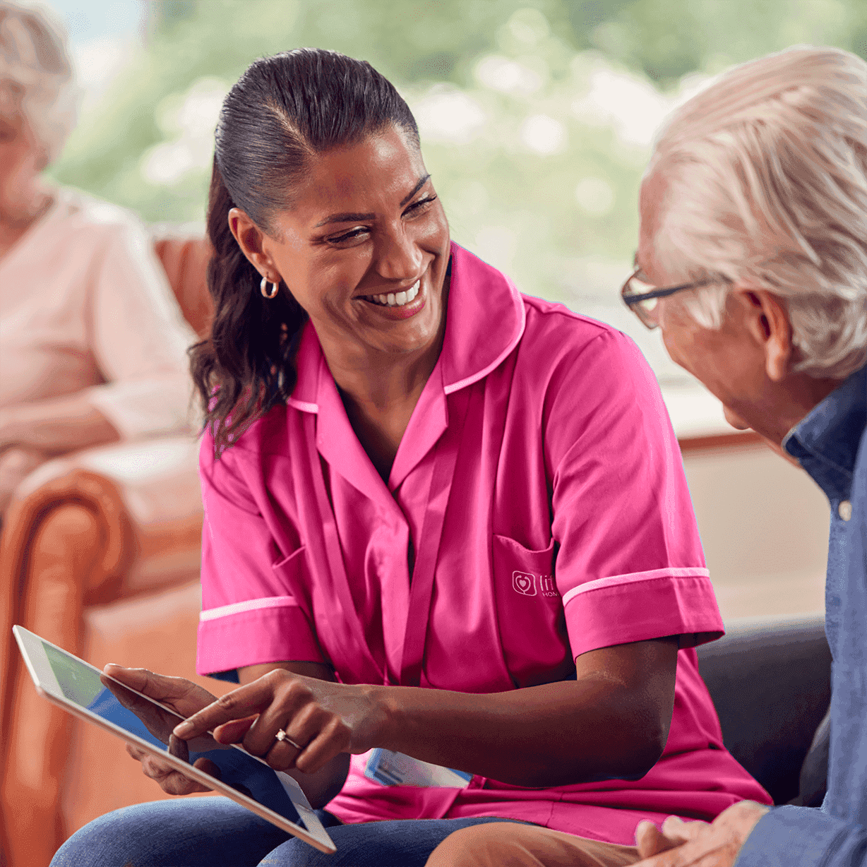senior man talking to female nurse care worker using digital tablet