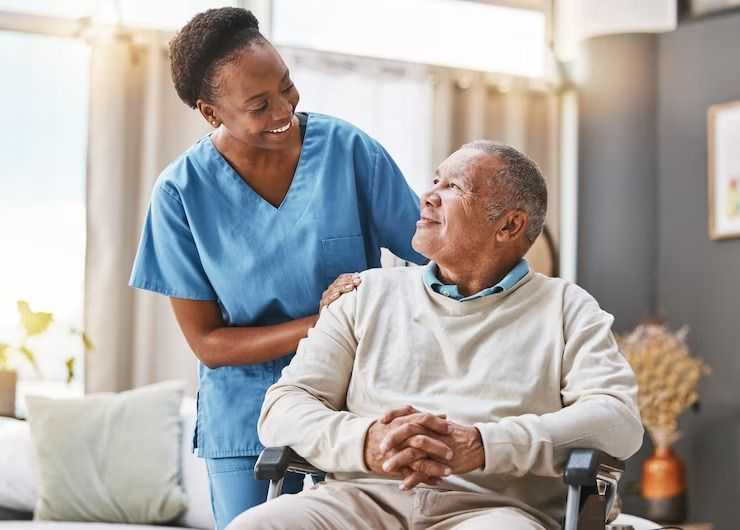 nuerse touching shoulder of senior man on wheelchair