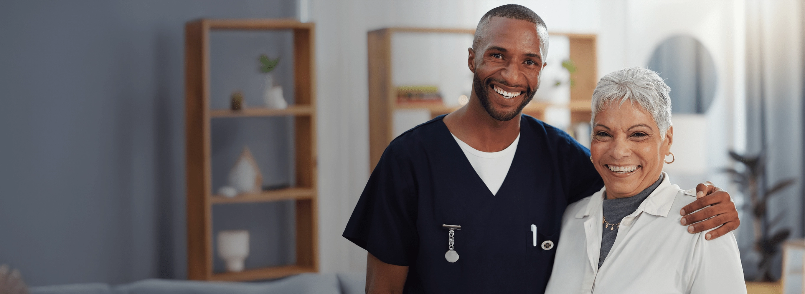 Life Medical Care provider with arm around happy elderly patient, representing personalized comprehensive healthcare delivered to the home.