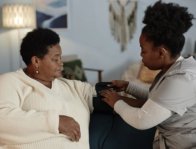 Nurse checking on senior woman during home primary care visit