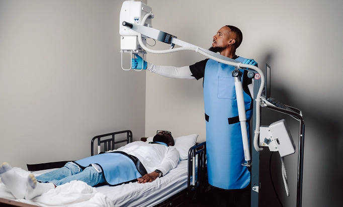 A radiologist operates a robotic arm for medical imaging